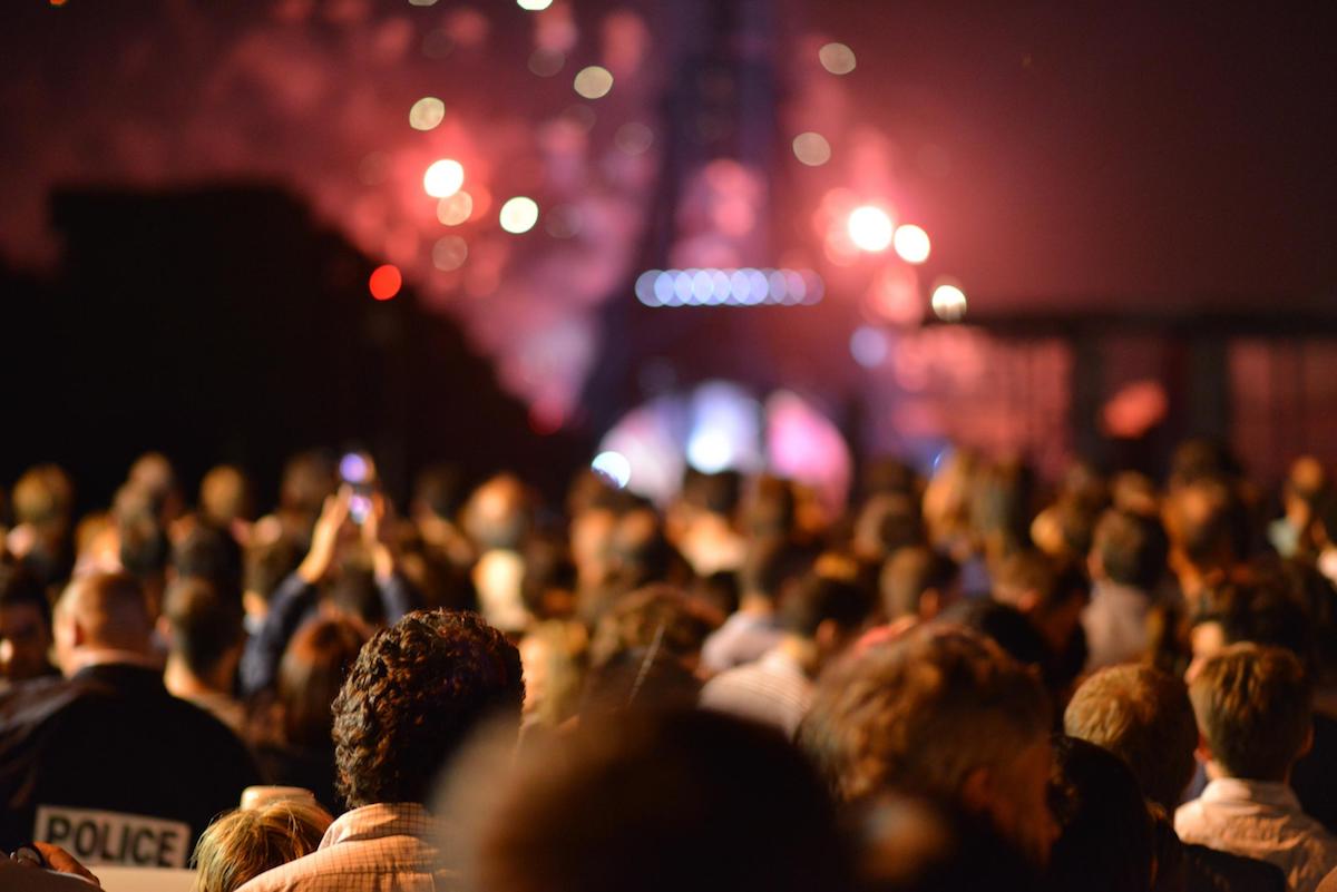 People celebrating in front of the Eiffel Tower at night.
